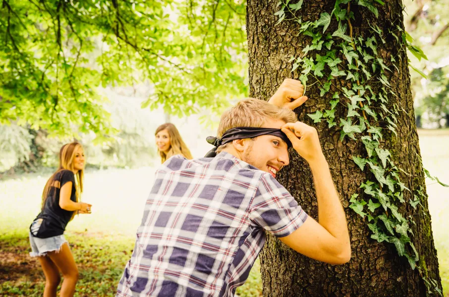 Des adolescents jouent à cache-cache dans un parc.