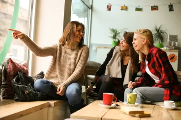 Un groupe de femmes partage un moment entre amis autour d’un café.