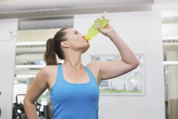 Femme sportive en train de boire pendant sa séance d’exercice pour s'hydrater