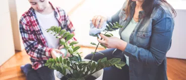 Une mère et son fils entretiennent une plante.